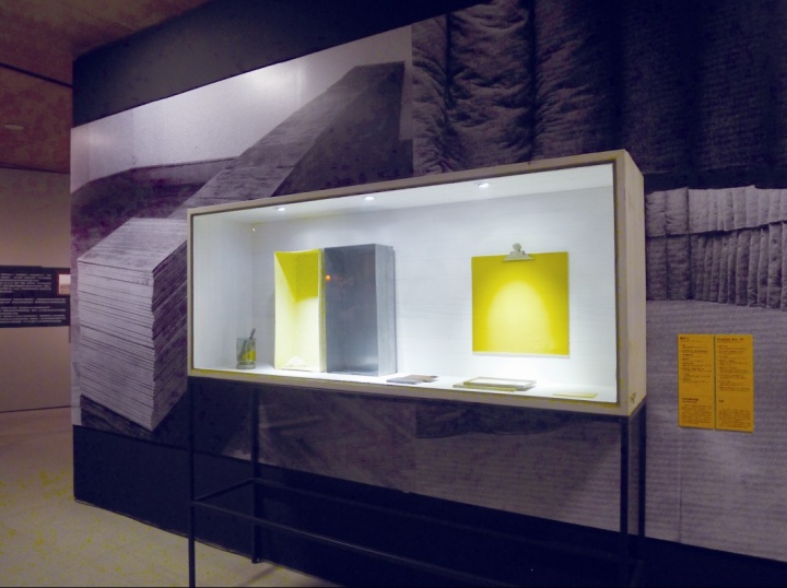 此次博伊斯的裝置作品多以展柜的形式展出，且每個(gè)展柜中集中了多個(gè)物件，比如圖中的展柜里擺放著涂抹硫磺的鋅盒、磁鐵垃圾、磁鐵名信片等，他的“雕塑”擺脫了把審美性放在首位的學(xué)院派模式，而強(qiáng)調(diào)其作為意義載體的性質(zhì)
