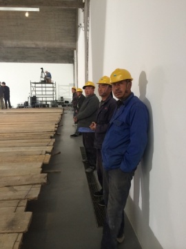 站在展廳兩邊的工人們，剛剛結(jié)束搭建作品“地”的最后一道工序