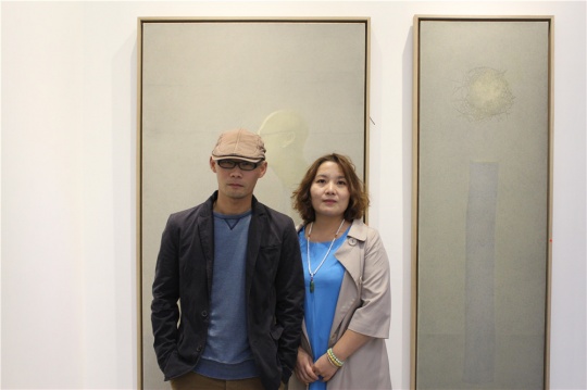 藝術家王永學與策展人丁浠文，背后的兩件作品在本屆CIGE已被收藏
