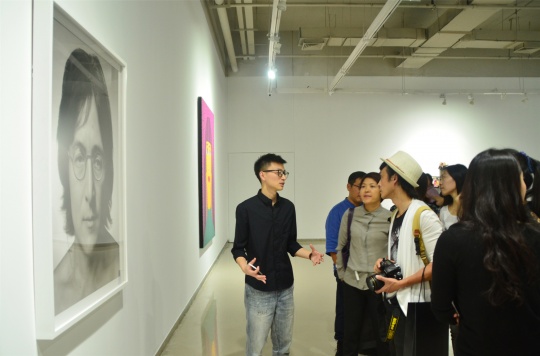 策展人陳澈為觀眾介紹張巍的攝影作品《約翰列儂》
