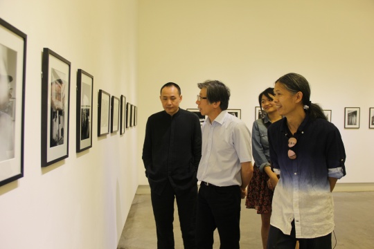 三影堂攝影藝術中心創(chuàng)始人榮榮（右一）與嘉賓中央美術學院院長范迪安（左二）觀看展覽
