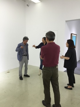 藝術(shù)家姜堯培（遠(yuǎn)處左一）向來賓介紹展覽作品
