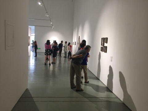 展覽現(xiàn)場仔細觀察作品的觀眾

