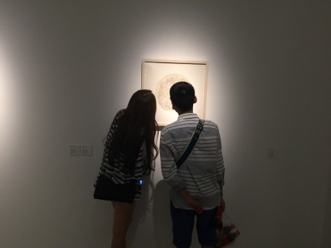 展覽現(xiàn)場，觀眾在觀察作品細節(jié)
