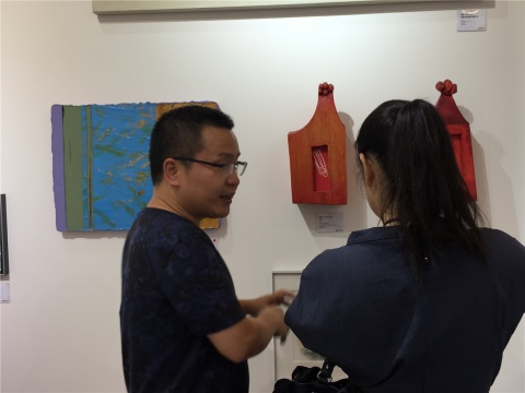 資深藝術(shù)品經(jīng)紀(jì)人伍勁與朋友在張淼作品《全頭》前交流
