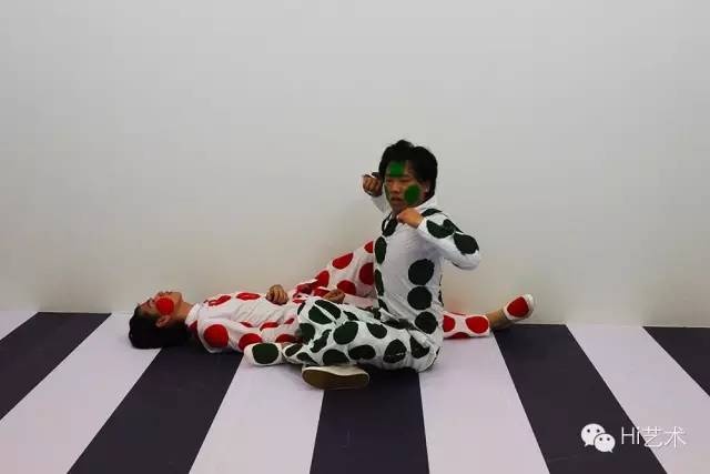 胡向前《兩個男人》
《兩個男人》是一場極具表現(xiàn)力的舞蹈，最初在室外的斑馬線上進行的演出。但當綠衣人和紅衣人被放置在“15個房間”的密閉空間里，進行每天例行8小時的演出時，他們將如何適應這個新的環(huán)境？對“兩個男人”進行解構(gòu)的語境正是讓藝術家為之著迷：當沒有交通可言的時候，紅綠燈會做些什么呢？
