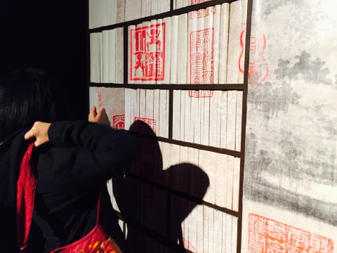 觀眾在山水中抽取書來閱讀，同時她也構(gòu)成作品的一部分
