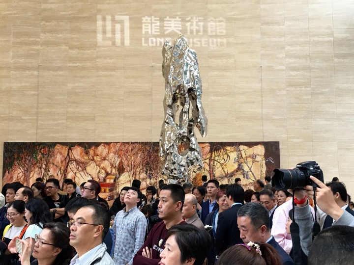 龍美術(shù)館重慶館開(kāi)館現(xiàn)場(chǎng)，金融中心大廳最醒目的是尹朝陽(yáng)巨幅新作和展望的雕塑作品。
