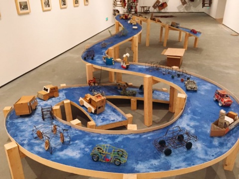 《藍色公路》木、肥皂、非洲兒童自制玩具，900x300x125cm，2003
2002年由于文化交流活動，我在剛果金沙薩駐留一個月。在六十年代的中國，我們的童年和此刻在金沙薩的非洲兒童一樣，只能玩自制的玩具。在這一個月的時間里，我和他們一起做了這些玩具，我用當?shù)氐陌沤度~做了條船，并將玩具放在船上。當我問他們“最想要的是什么”時，孩子們回答：“離開這個國家”。當我回到歐洲后的一個展覽中，我做了“藍色公路”，并將非洲兒童們與我一起做的交通玩具放在上面。
