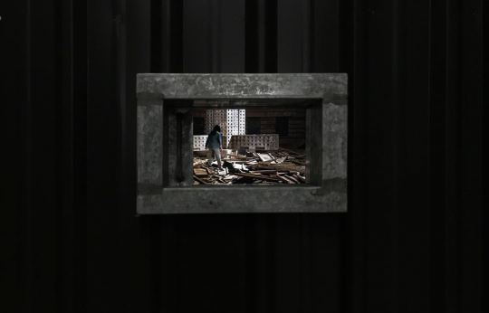 《無(wú)居所者、租屋者、房貸者的肖像》，陳界仁與他的工作伙伴，借來(lái)蓋完公寓后拆卸下的木造模板，重新搭建一個(gè)堆滿模板的工地場(chǎng)景，場(chǎng)景中央有一個(gè)像是由集合住宅與監(jiān)獄迭影而成的大廈模型

