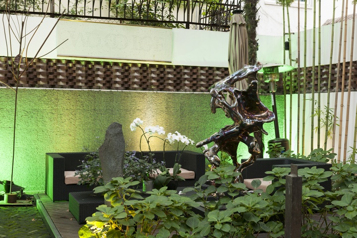 展望近兩年的不銹鋼雕塑新作，石頭是隋建國的作品。椅子旁像樹枝一樣的作品是高偉剛2018年創(chuàng)作的《家》。院墻上是陳哲的水磨石作品《狗狼暮色》，如果不是金色的上下框，很容易將它忽略。
