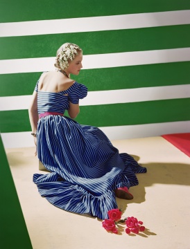 連衣裙：哈蒂 · 卡內(nèi)基
1939
美國版《Vogue》， 1939.6.15
顯色印刷
致謝霍斯特遺產(chǎn)委員會/康泰納仕
一款簡約的荷葉邊連衣裙，面料為涼爽的藍色軟薄綢，并采用類似男士領帶的條紋圖案 …… 這是一款全新的柔軟特制面料。前后均為低平領口設計。選擇這款連衣裙，為炎炎夏夜增添一絲沁心涼意。搭配藍色珠鏈和與腰帶相呼應的紅色拖鞋。云鬢淺挽，鈴蘭為飾，素雅而別致。

